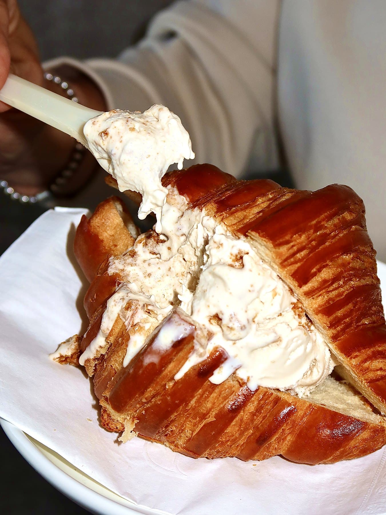 Croissant ice cream sandwich with a wooden spoon