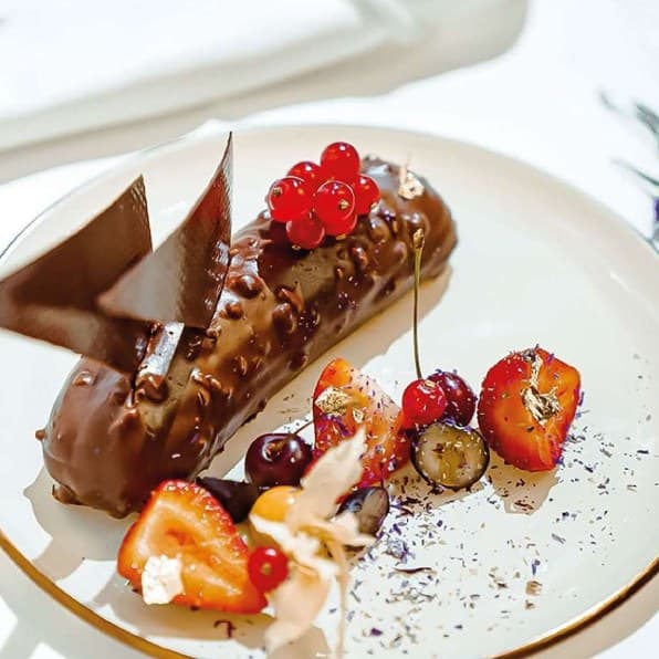 Chocolate éclair with chocolate shards and seasonal fruit
