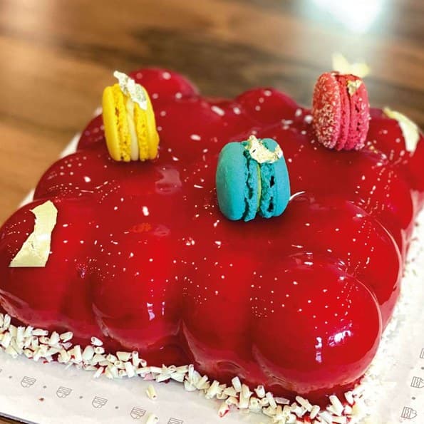 Cloud-shaped ruby-glaze entremet topped with macarons
